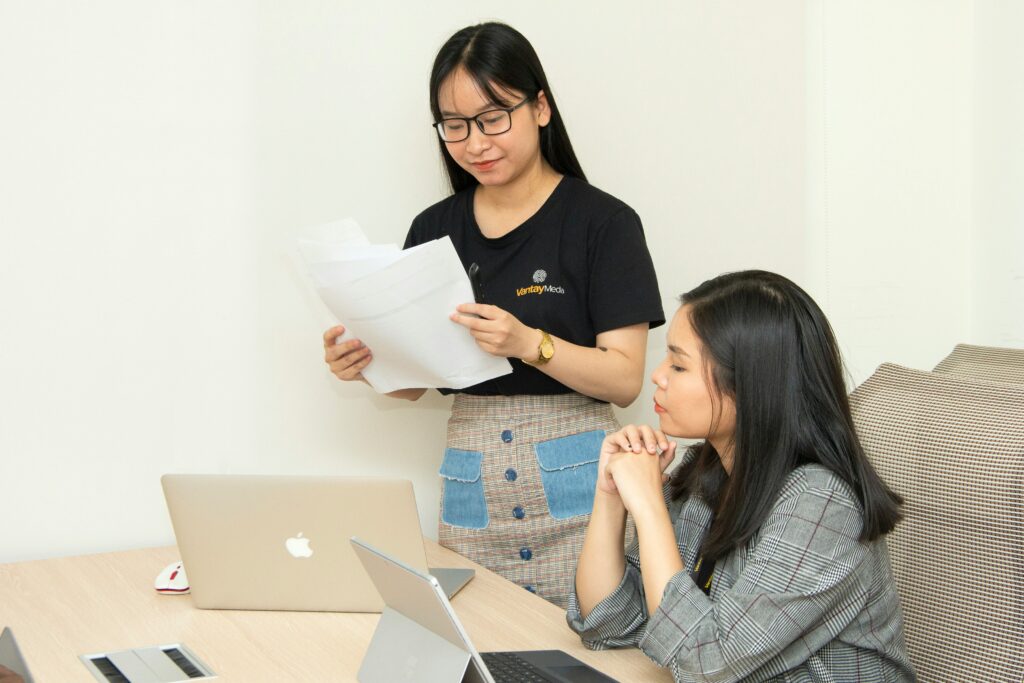 Two people reviewing documents whilst on their computer